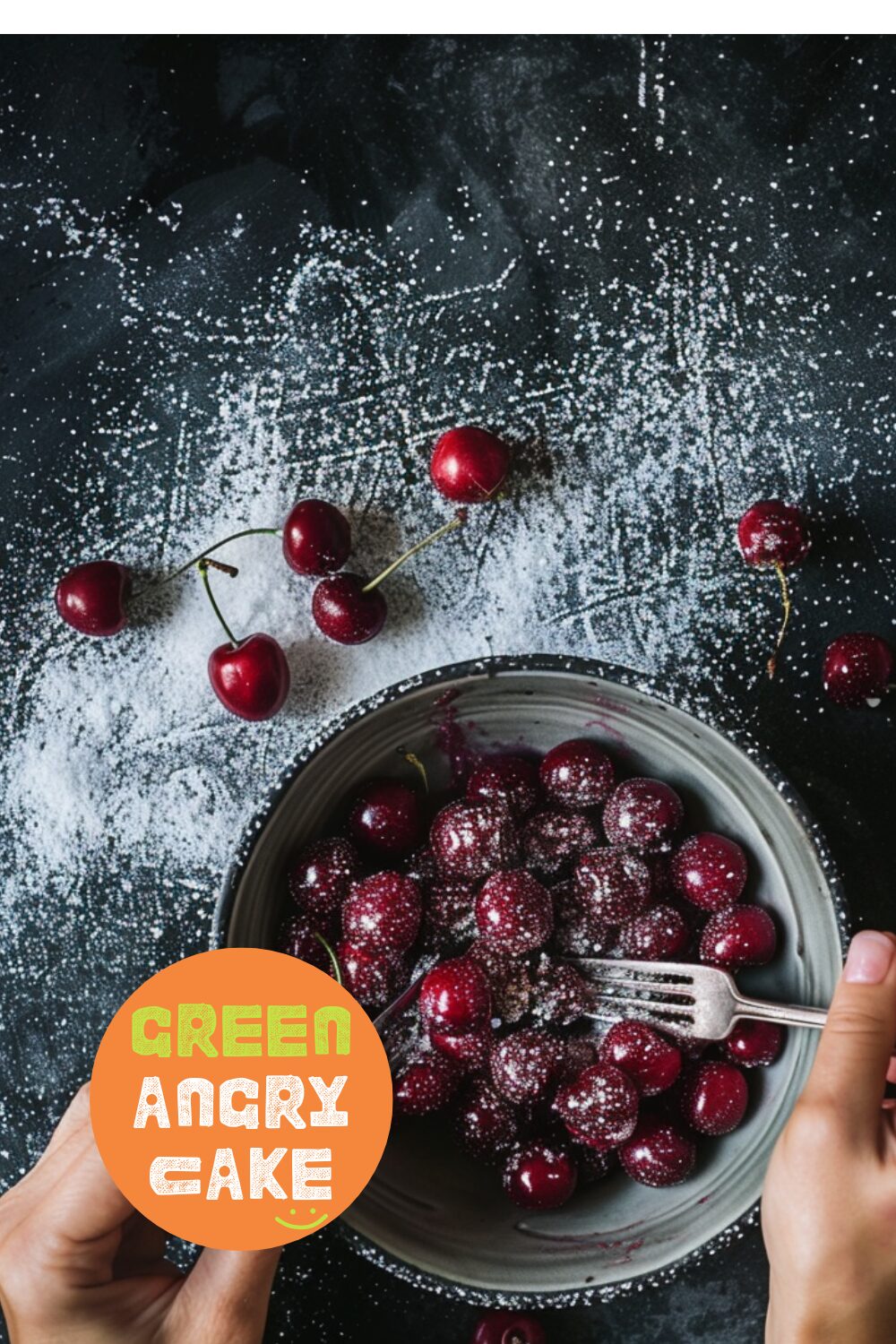 Hands crushing cherries with a fork in a small bowl, with sugar sprinkled over them, on a dark wooden surface