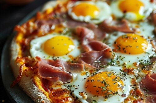 Top-down view of breakfast pizza with ham and mini sunny side up quail eggs on a red plate, on a dark wooden surface.