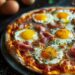 Top-down view of breakfast pizza with ham and mini sunny side up quail eggs on a red plate, on a dark wooden surface.