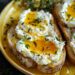 A yellow plate of ricotta toast topped with honey and thyme on a dark wooden surface.