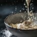 Close-up shot of a mixing bowl with sour cream and spices being stirred on a dark, black wooden texture surface.