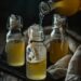 Homemade elderflower cordial being poured into sterilized bottles through muslin, placed on a dark wooden surface